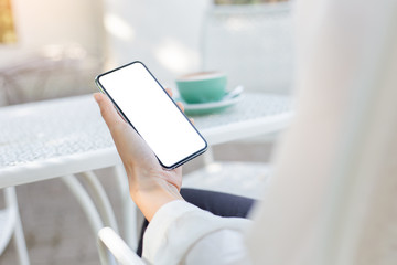 Mockup image blank white screen cell phone.woman hand holding texting using mobile on desk at coffee shop.background empty space for advertise text.people contact marketing business,technology