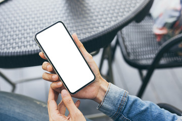 Mockup image blank white screen cell phone.woman hand holding texting using mobile on desk at coffee shop.background empty space for advertise text.people contact marketing business,technology