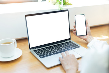 mockup image blank screen computer,cell phone with white background for advertising text,hand woman using laptop texting mobile contact business search information on desk in cafe.marketing,design