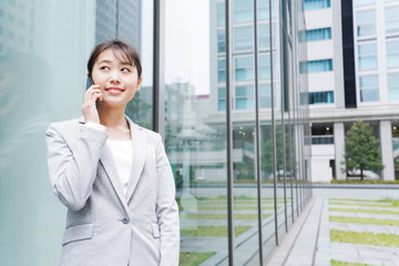 オフィス街で電話をする若いビジネスウーマン