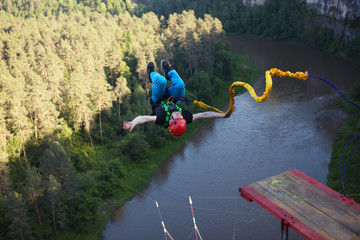 Extreme athlete, tied to a safety rope, makes a leap with a coup and falls into a deep canyon from...