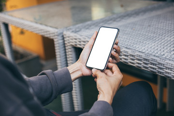 Mockup image blank white screen cell phone.woman hand holding texting using mobile on desk at coffee shop.background empty space for advertise text.people contact marketing business,technology