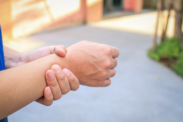 Close up man holding her wrist symptomatic Office Syndrome.People, healthcare and problem concept - close up of man suffering from pain in hand wrist at home