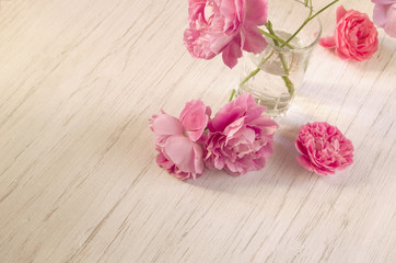 Vintage rose flowers on light wooden background, copy space