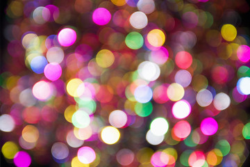 Pink, yellow and blue blurred festive bokeh. Christmas bright light holiday background.