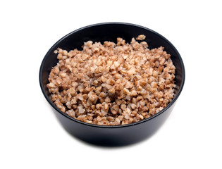 Vegan low calorie food, baked buckwheat in black round bowl studio shot isolated on white background front view