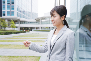 オフィス街でキャッシュレス決済をするビジネスウーマン