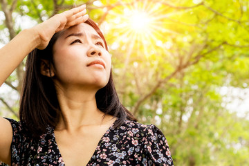 Asian woman having problem sunburn ,melasma, freckles on skin, hand cover her face to protect UV...