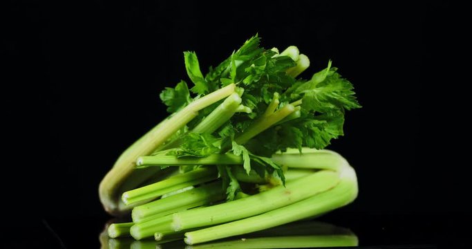 A bunchs of fresh celery slowly rotate.