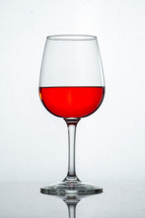 Copa de cristal con liquido rojo y fondo blanco