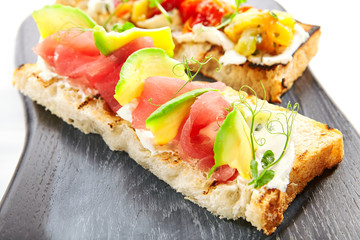 Tasty bruschetta with fish and baked peppers