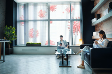 Couple staying at home, using phones, siting on sofa at home, using social media, ignoring...