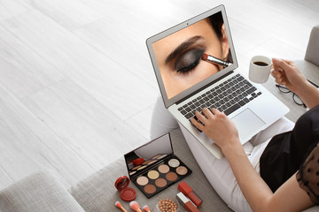 Female makeup artist with laptop at home - obrazy, fototapety, plakaty