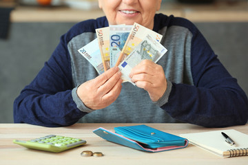 Senior woman counting money at home