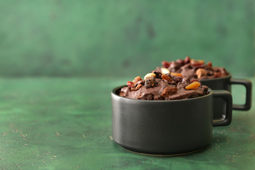 Chocolate mug cakes on color background