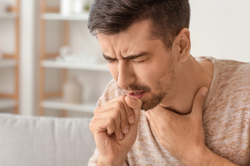 Coughing young man at home