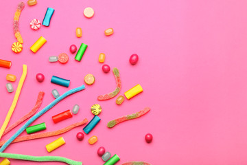 Assortment of sweet candies on color background