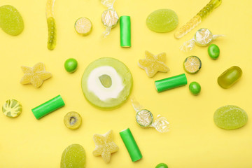 Assortment of sweet candies on color background