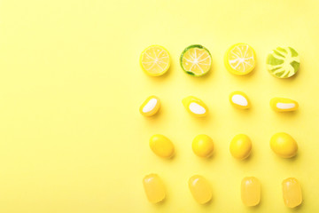 Assortment of sweet candies on color background