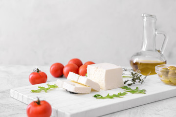 Tasty feta cheese with herbs on white background