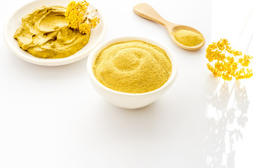 Yellow cosmetic clay - skin cleansing concept - on white background