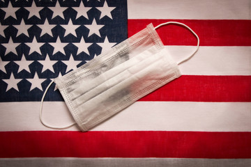 CORONAVIRUS. Protective medical mask on the background of the American flag . Concept of protection...