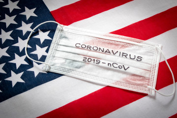 CORONAVIRUS. Protective medical mask on the background of the American flag . Concept of protection against coronavirus.