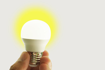 Close up hand holding an light bulb isolated on white background