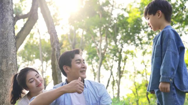 young asian mother father and son relaxing having fun outdoors in woods