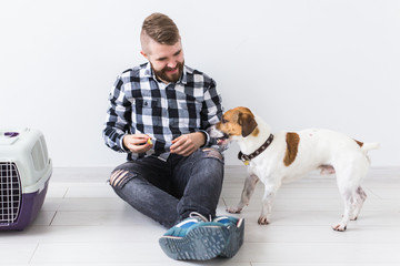 Pets owner concept - Attractive cheerful male in plaid shirt holds favourite pet. Happy bearded man with his jack russell terrier