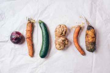 Spotted carrot, eggplant, beetroot. Ugly vegetables on grey background. Ugly food concept. Top...