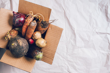 Donation box full of non gmo vegetables on craft paper background. Concept of zero waste...