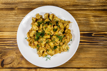 Stewed mushrooms with sour cream on wooden table. Top view