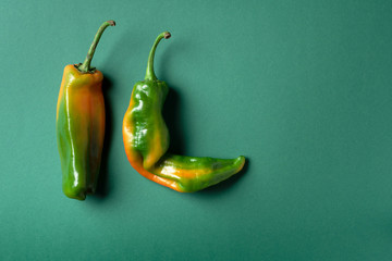 Ugly bell pepper on green background. Concept of zero waste production. Top view. Copy space. Non...