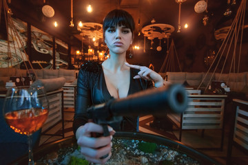 Portrait of a sexy young woman with a gun in her hands close up. - obrazy, fototapety, plakaty