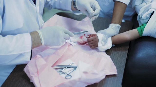 Doctor healing cut of a baby boy on the emergency room, 4k