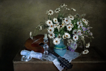 Classic still life with a musical instrument, a bouquet of daisies and a candle
