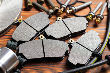 brake parts on wooden background  brake pads, disc, brake hose, guides, cylinders- Image