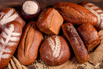 Fresh baked brown bread on a brown concrete background. Freshly baked traditional bread on a dark background. 