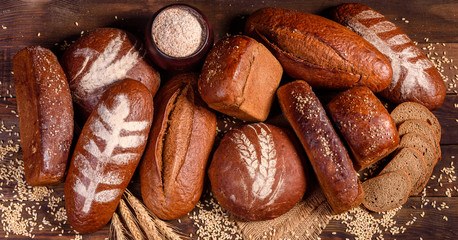 Fresh baked brown bread on a brown concrete background. Freshly baked traditional bread on a dark background. 