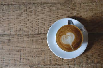 Wood office desk table with cup of latte coffee and supplies. Top view with copy space, flat lay.
