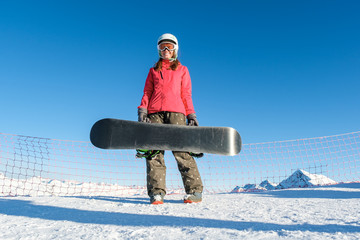 Picture of happy young lady snowboarder on the slopes