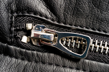 Fragments of a black artificial leather jacket with rivets and zippers. Background for clothes and...