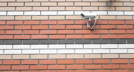 CCTV camera on a brick wall. Tracking and surveillance system for the house and the surrounding...
