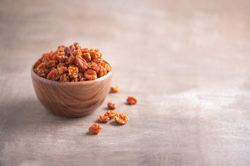 Dried physalis in wooden bowl on wood textured background. Copy space. Superfood, vegan, vegetarian food concept. Macro of inca berries, selective focus. Healthy snack.