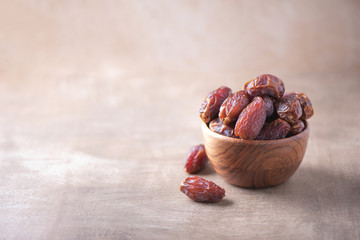 Dried date fruit in wooden bowl on wood textured background. Copy space. Superfood, vegan,...