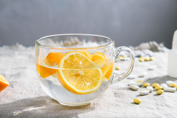 glass Cup with lemon slices and clear water for close-up on a table with medicines as an alternative medicine
