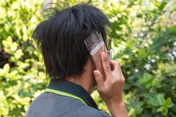 Men use plastic bag to cover mobile phone to prevent the covid-19 virus.