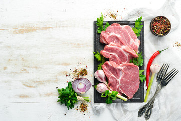 Raw veal meat with parsley and spices on the table. Beef steak. Top view. Free space for your text. Rustic style. - obrazy, fototapety, plakaty