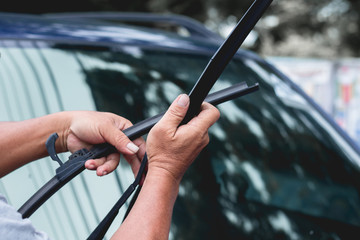 Mechanic replace windshield wipers on car. Replacing wiper blades